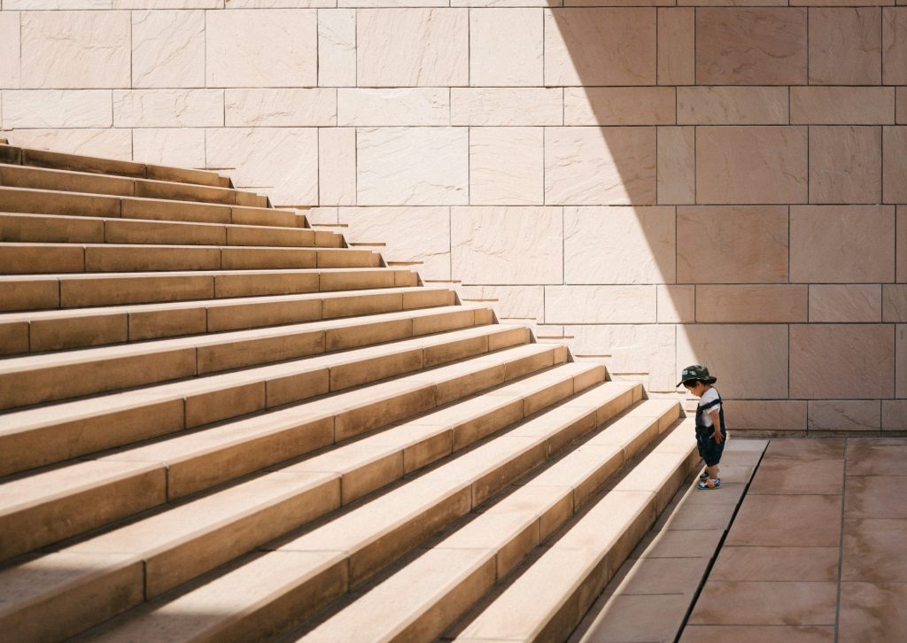 Kid facing the challenge of large stairs illustrating the diminishing returns that OpenAI is reportedly facing with the training and development of its latest AI model.