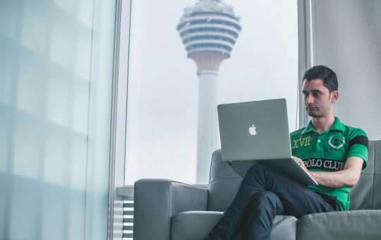 Man working on a computer illustrating a report from the Tony Blair Institute highlighting AI's potential impact on the workforce, including the opportunities and risks to the labor market and how government and policymakers can mitigate the challenges.